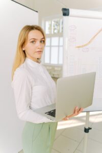 Femme d'affaires confiante présentant des données dans un environnement de bureau lumineux.