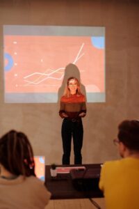 Une femme présente des données avec une projection graphique lors d'une réunion d'affaires.